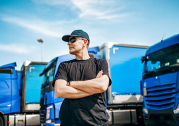 Driveforce New Zealand | driver standing in front of trucks, logistics and driving jobs
