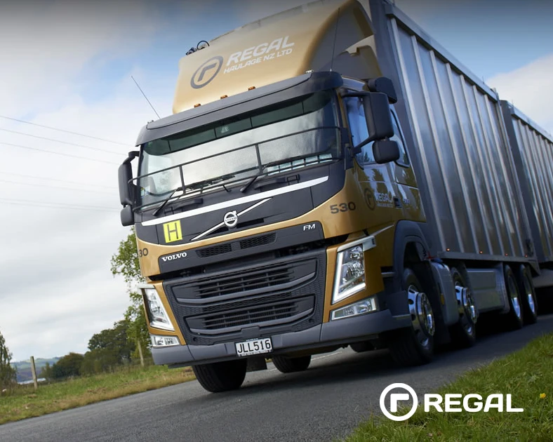 Low angle photo of large truck on sealed road. The Regal Group logo overlaid bottom right corner.